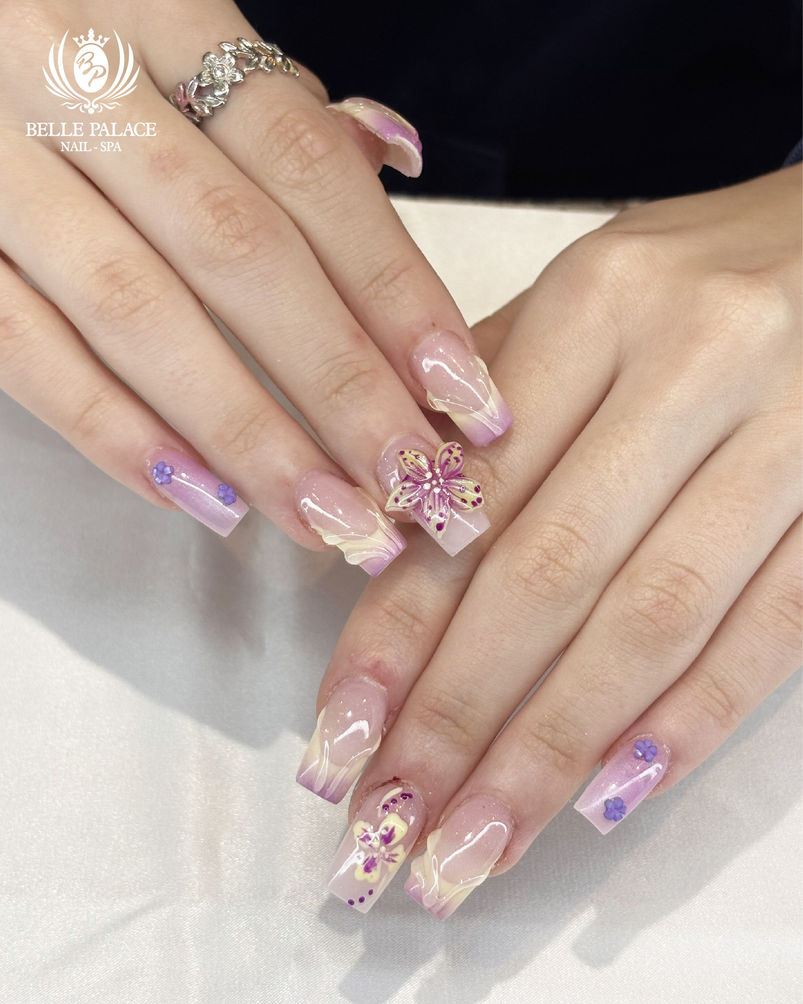 Pink and purple nails with 3D flower designs